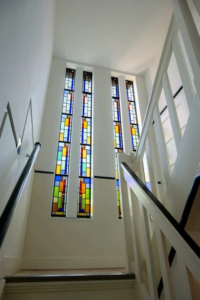 Monument renovatie verbouwen glas in lood renovatie trappenhuis lange verticale ramen